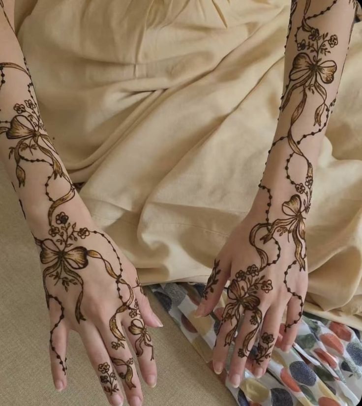 a woman's hands with henna tattoos on them