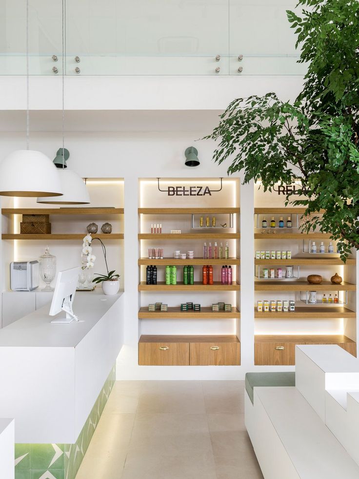 a store filled with lots of bottles and shelves next to a tree in front of it