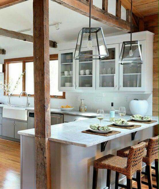 a kitchen with white cabinets and wooden floors is shown in this image, there are three chairs at the center of the island