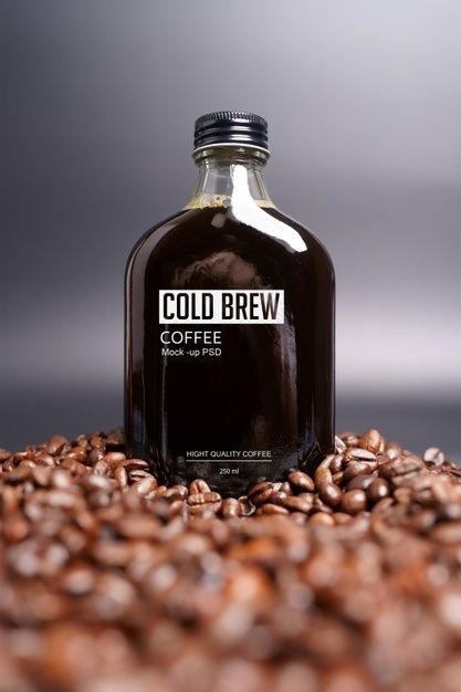 a bottle of cold brew coffee sitting on top of some coffee beans with the label coldbrew