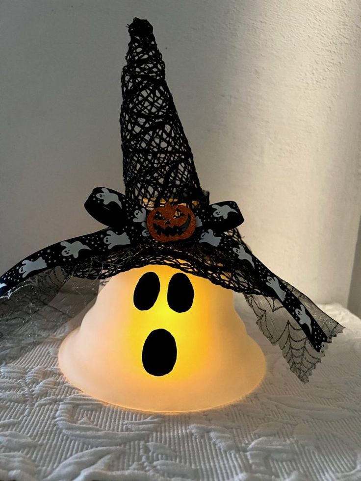 a lighted halloween decoration with a ghost hat