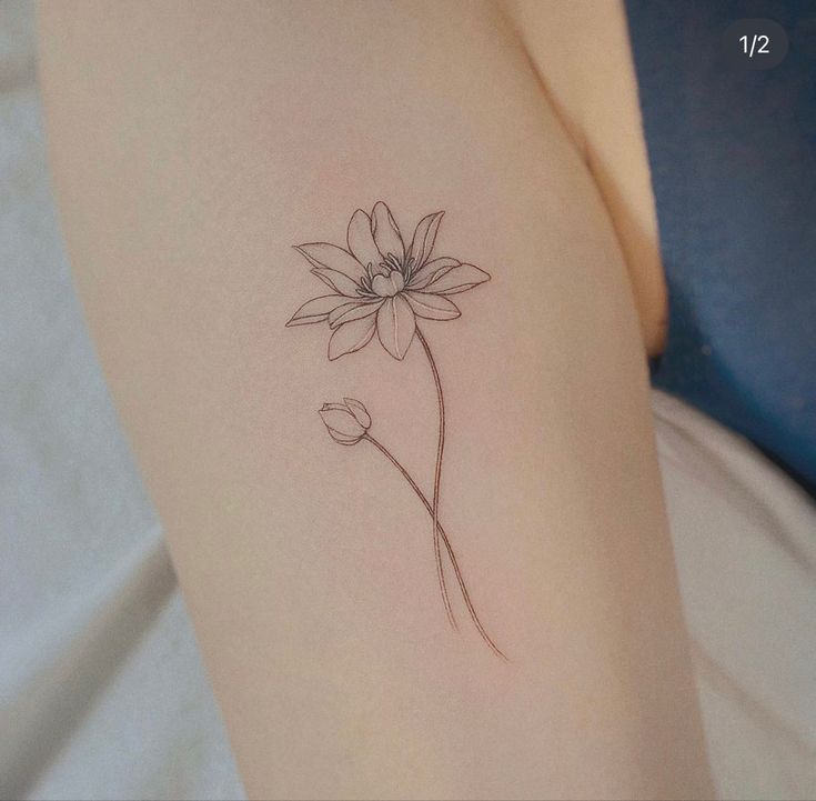 a single flower tattoo on the arm