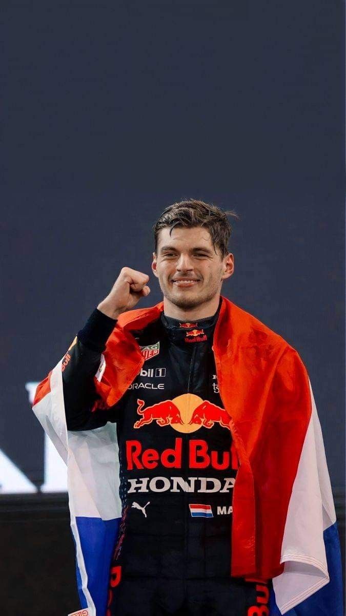 a man holding up his red bull jersey