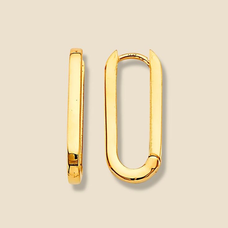 a pair of gold - plated metal clip earrings on a white background, with the letter o in the middle