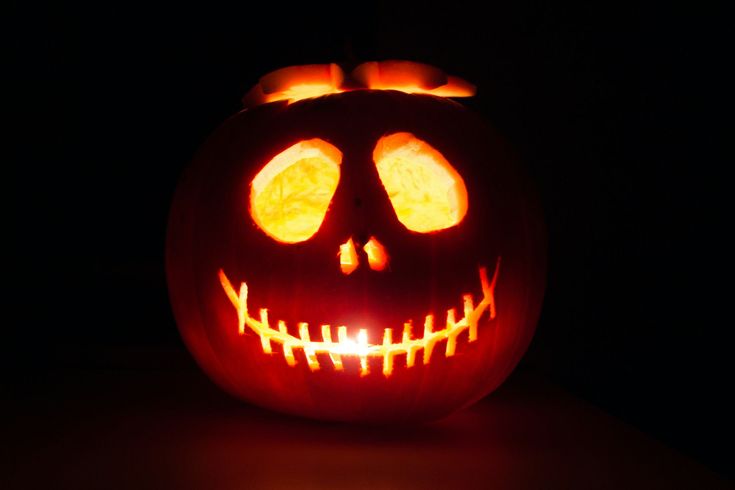 a carved pumpkin with glowing eyes and teeth