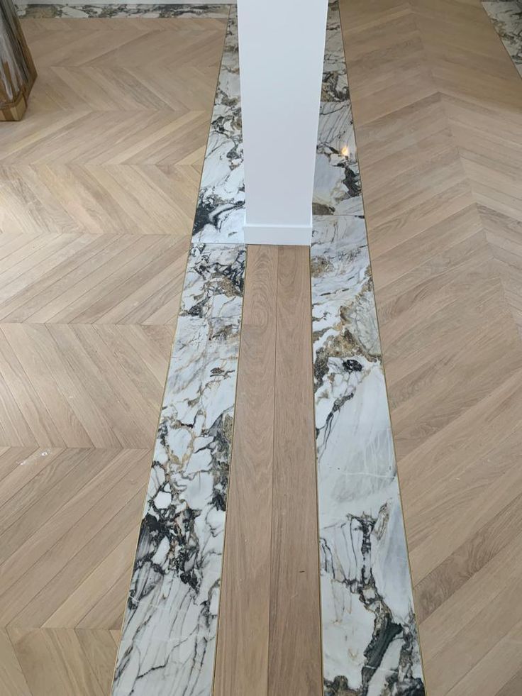 the floor is made up of marble and wooden planks, along with a white pedestal