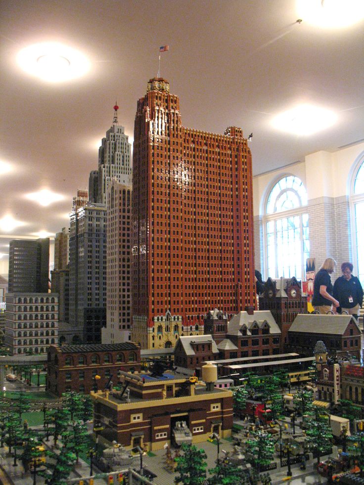 a model of a city is shown with people looking at the buildings in the background