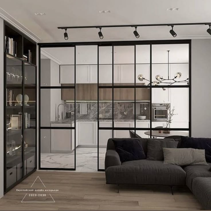 a living room filled with furniture next to a kitchen