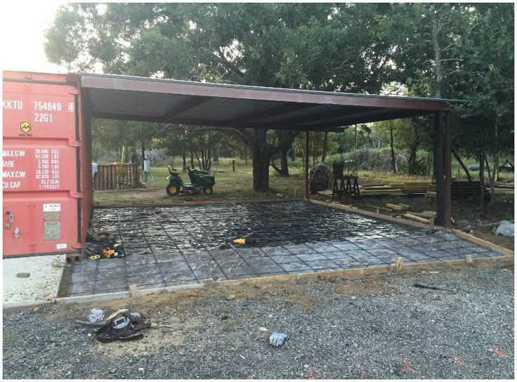 an outdoor covered area with several items on the ground and trees in the backgroud