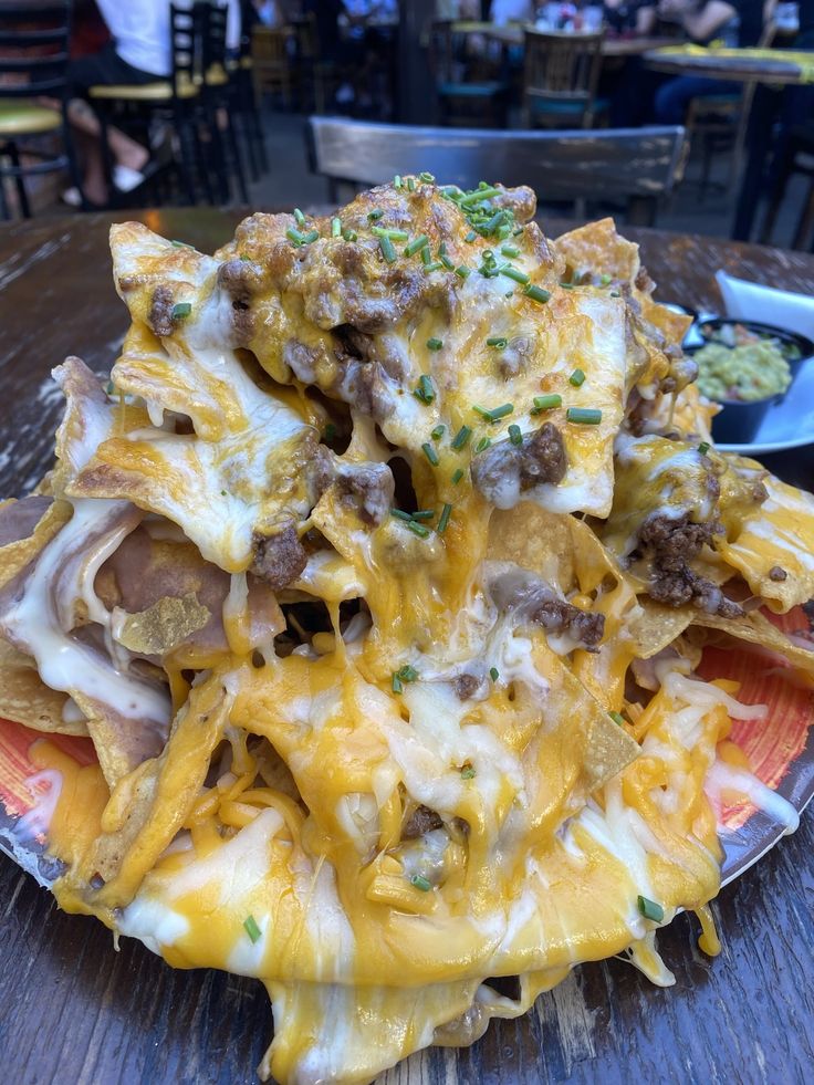 a plate full of nachos with cheese and meat