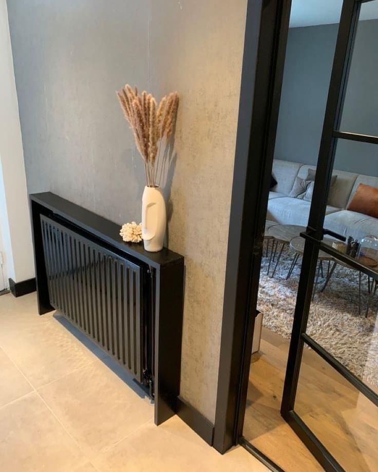 a vase sitting on top of a wooden shelf next to a glass door in a living room