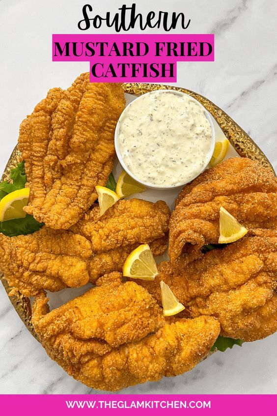 fried fish is served on a plate with lemon wedges and ranch dressing in the background