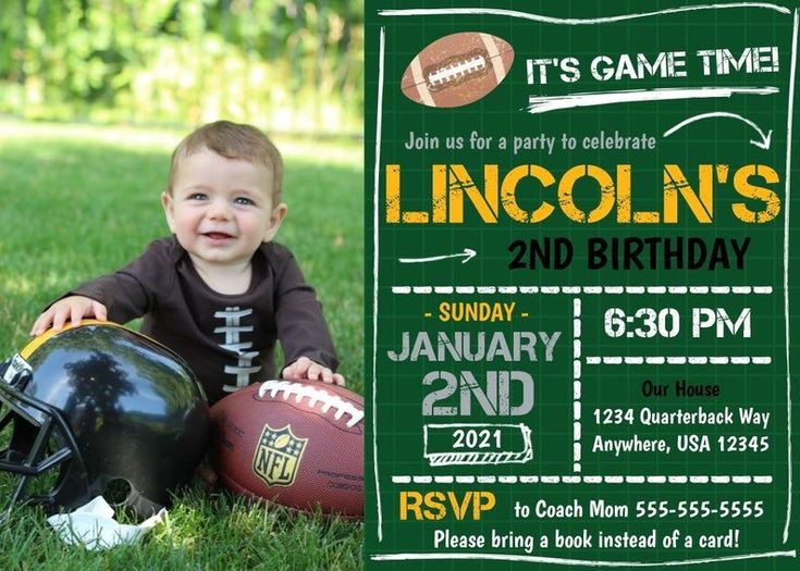 a little boy sitting in the grass with a football and helmet on his chest, next to a chalkboard sign that says it's crossing the one yard line