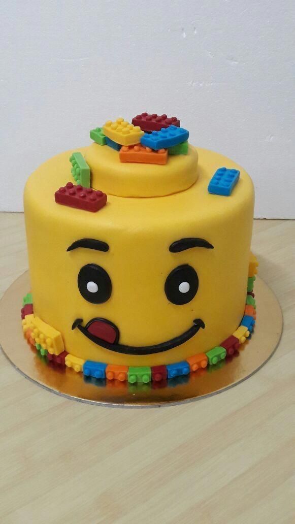 a yellow cake with legos on it sitting on a table