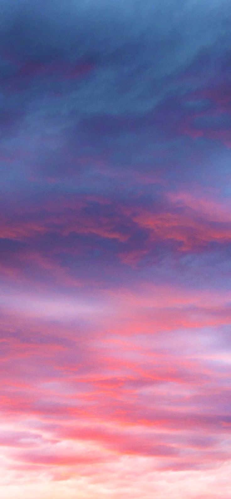 an airplane is flying in the sky with pink and blue clouds behind it at sunset