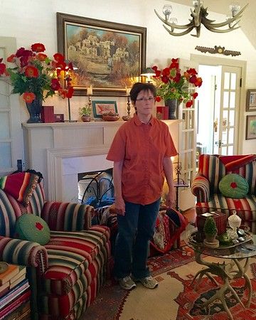 a man standing in the middle of a living room filled with colorful couches and rugs