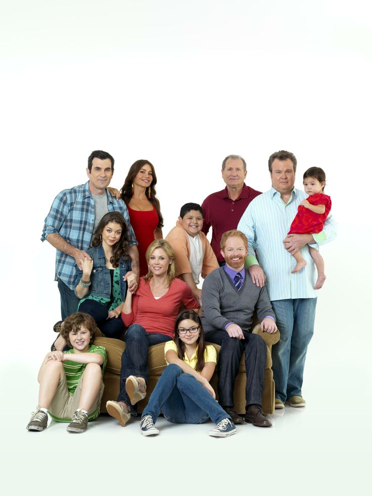 a group of people sitting on top of a couch with one person holding a baby