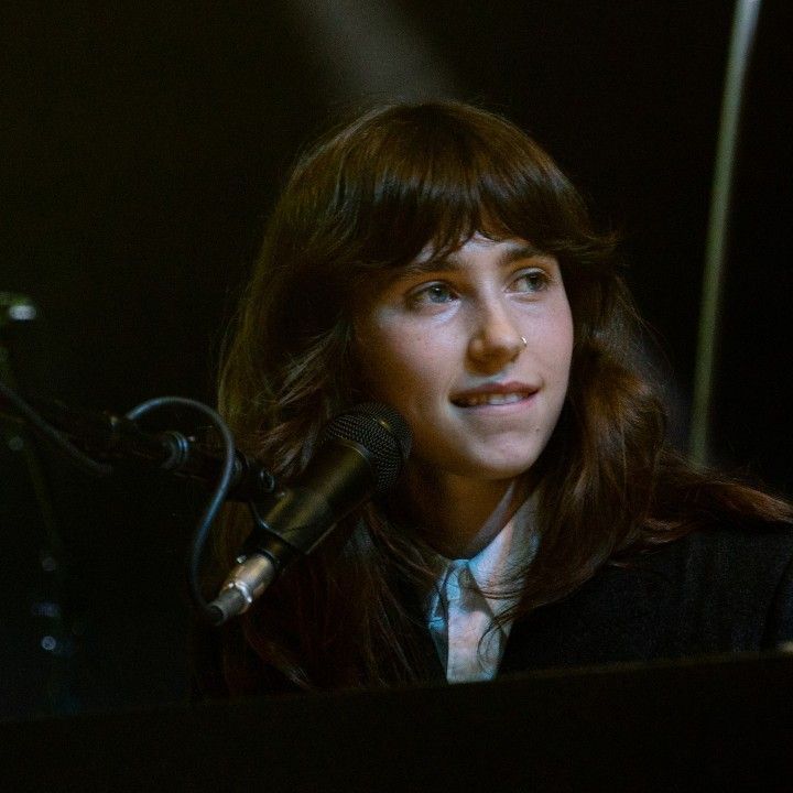 a woman sitting in front of a microphone