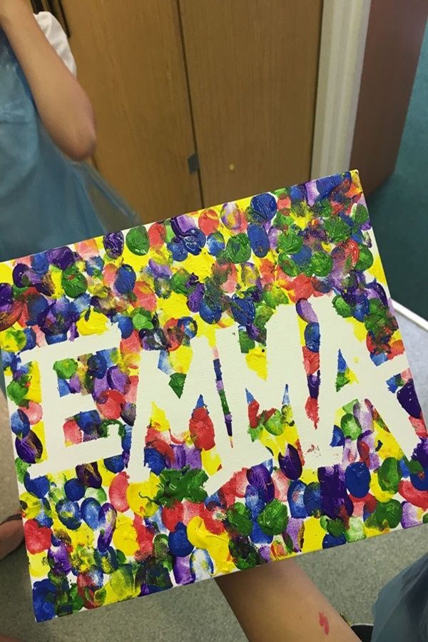 a child holding up a piece of paper with the word fam painted on it