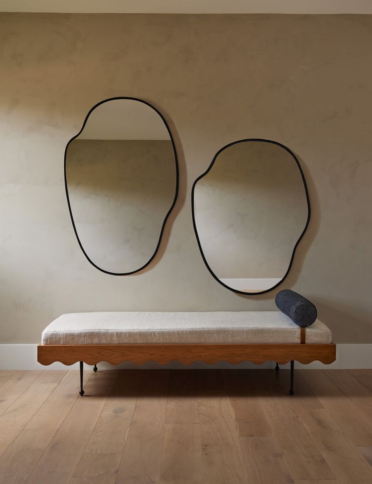 a bench with two mirrors on the wall above it