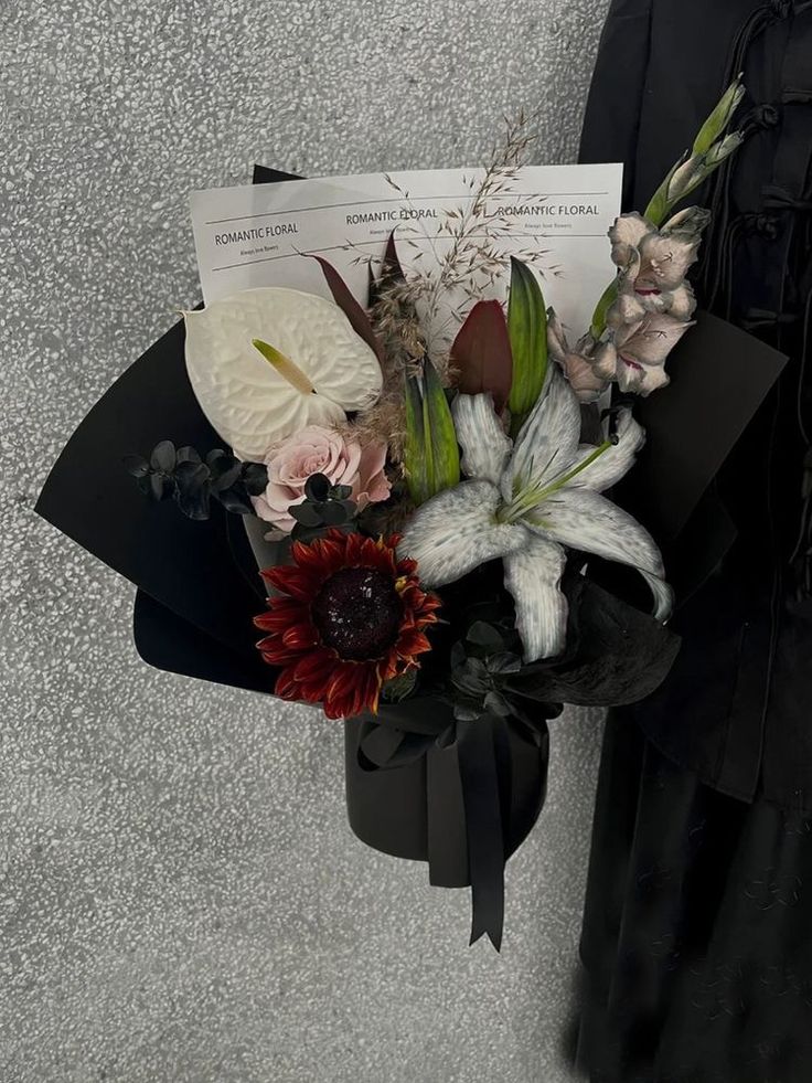 a bouquet of flowers sitting on top of a piece of paper next to a wall