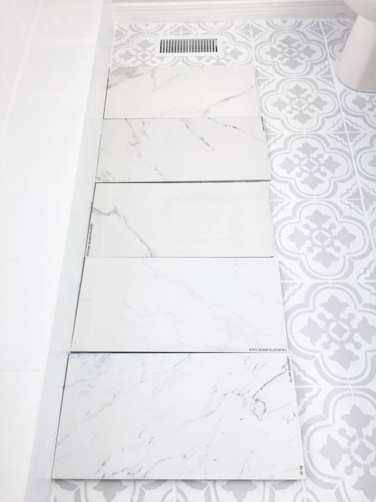 a bathroom with white and gray tile on the floor