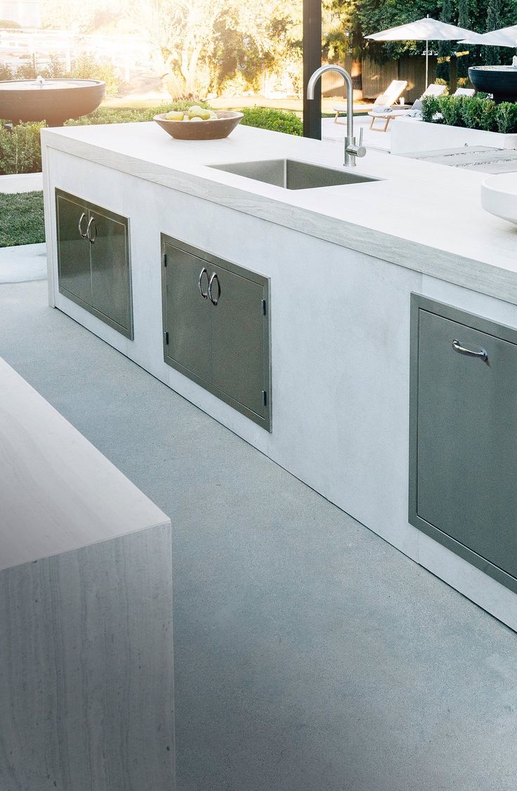 an outdoor kitchen with stainless steel sinks and cabinets