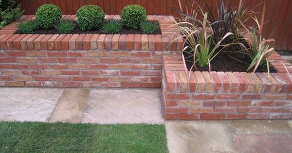 a brick planter with plants growing in it