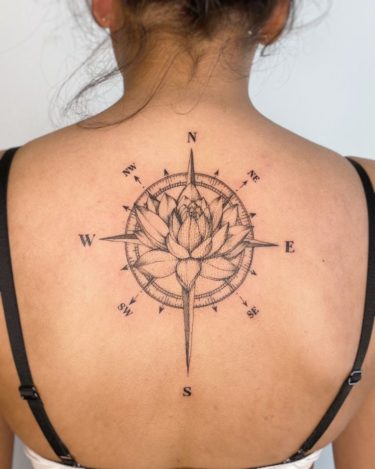 a woman with a compass tattoo on her back