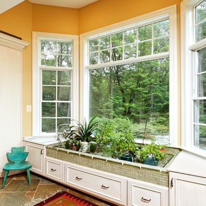 a room filled with lots of windows next to a green planter on top of a window sill