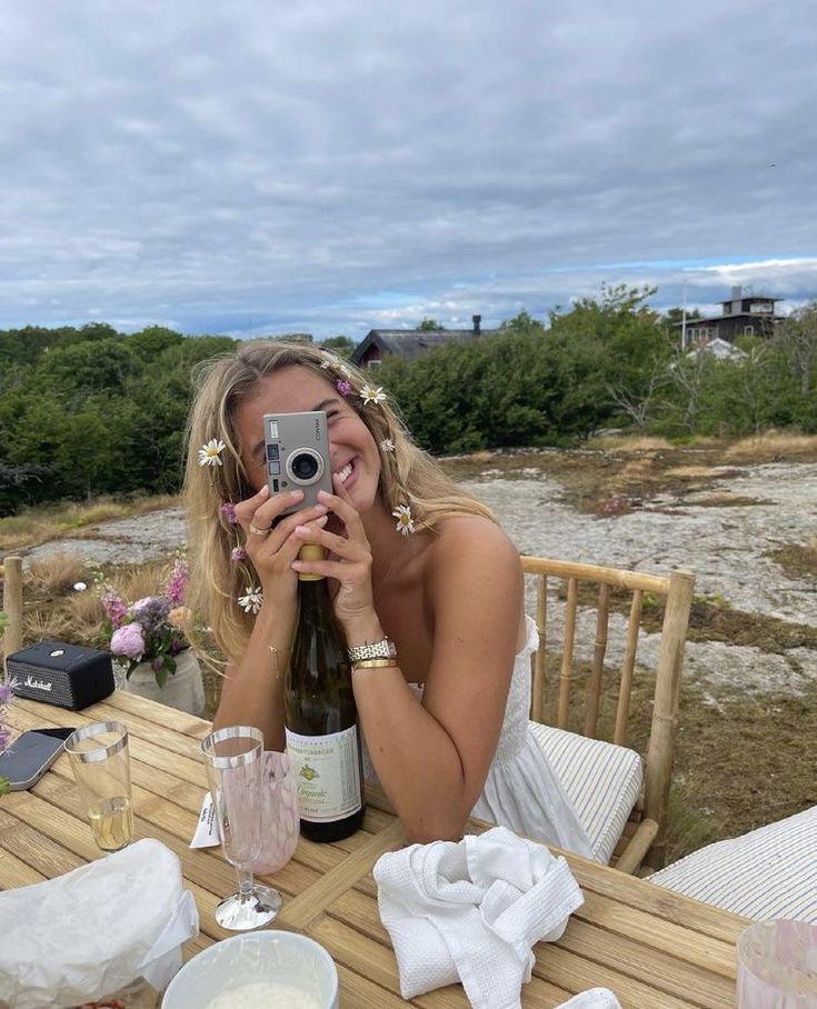 a woman sitting at a table taking a selfie