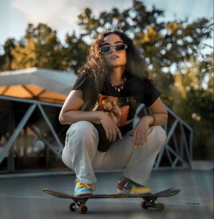 a woman sitting on top of a skateboard in front of a building with trees