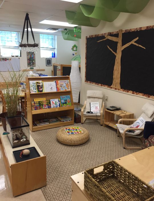 an image of a classroom setting with pictures on the wall and bookshelves in the middle