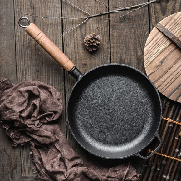 a cast iron skillet sitting on top of a wooden table