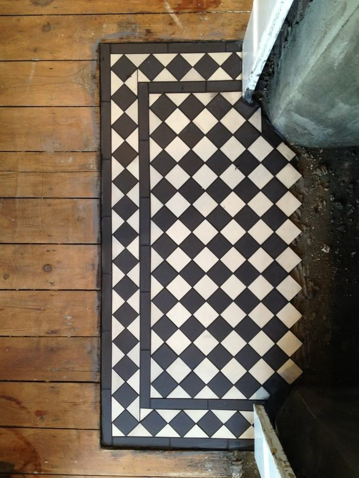 a black and white tile floor with a door in the center on top of it