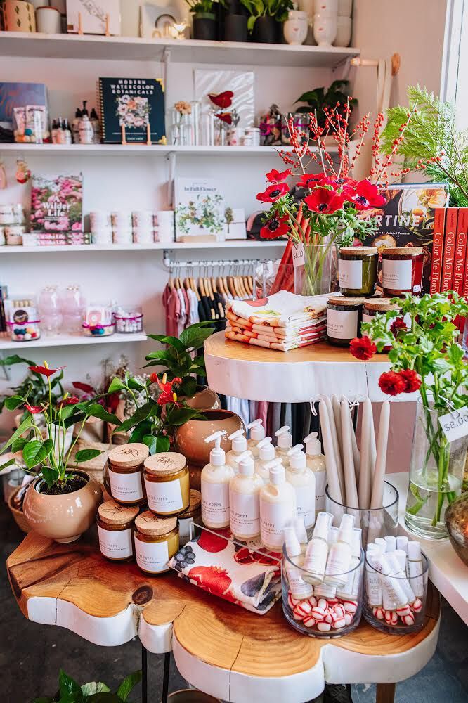 a table filled with lots of different types of items and flowers in vases on top of it