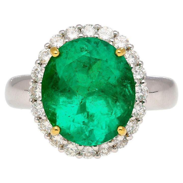 GRS certified 5.03-carat oval cut Colombian Emerald and round cut white diamond halo ring in 18k white gold. The center stone Emerald bears minor oil treatment and a faceted oval cut shape. The stone is eye-clean and full of life. Complemented with wonderfully contrasting yellow prongs and a white gold ring shank. Open back culet to reflect Emerald's natural vibrant color. Item Details: - Type: Engagement Ring - Metal: 18K White, Yellow Gold - Weight: 6.43 Grams - Setting: Prong - Size: 7.5 (adj Ring Shank, Diamond Halo Ring, Oil Treatments, Colombian Emeralds, Diamonds Ring, Gemstones Jewelry, Halo Diamond Ring, White Gold Ring, Halo Rings