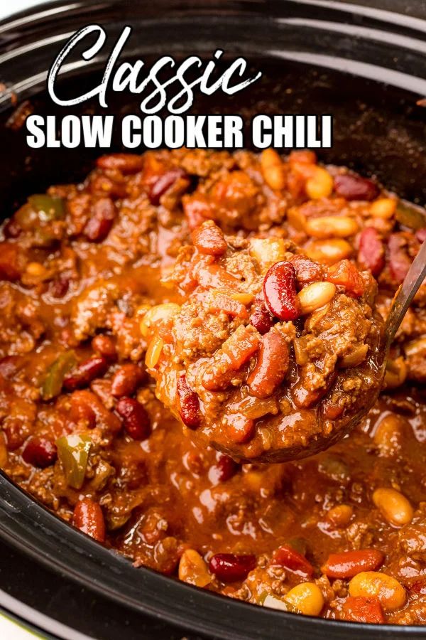 slow cooker chili with meat and beans in it being spooned into the crock pot