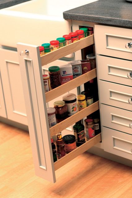 an open cabinet in the middle of a kitchen with spices and condiments on it