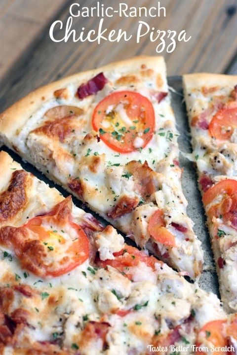 a close up of a pizza on a pan with tomatoes and chicken in the middle