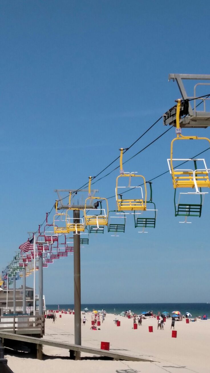 the beach is crowded with people and ski lifts