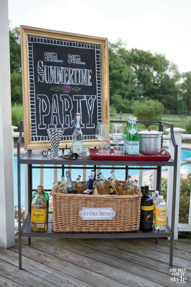 an outdoor party with drinks and snacks on a table next to a chalkboard that says summertime party