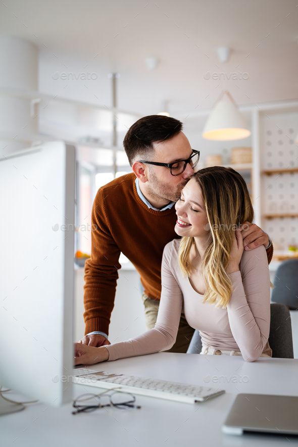 a man and woman are looking at a computer screen together - stock photo - images