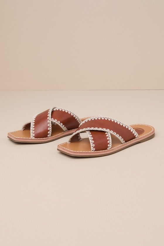 a pair of brown and white sandals sitting on top of a table