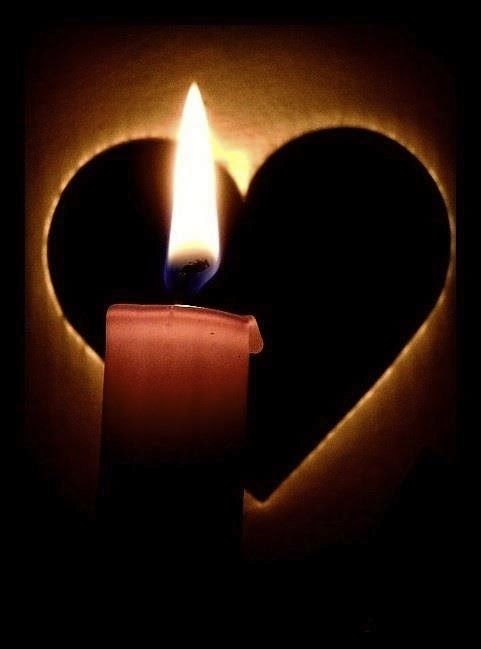 a candle in the shape of a heart with a lit candle on it's side