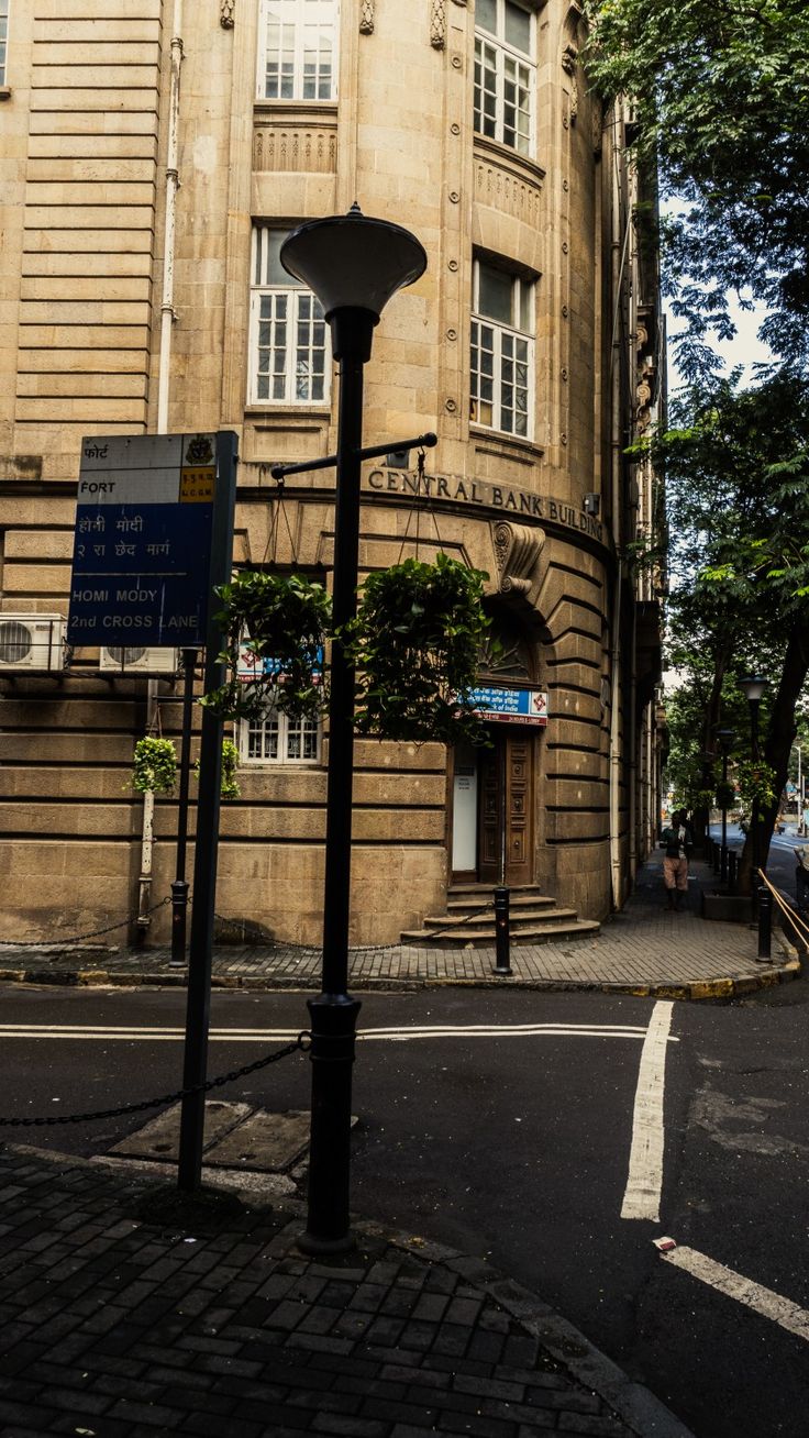 an old building on the corner of a street with a lamp post in front of it