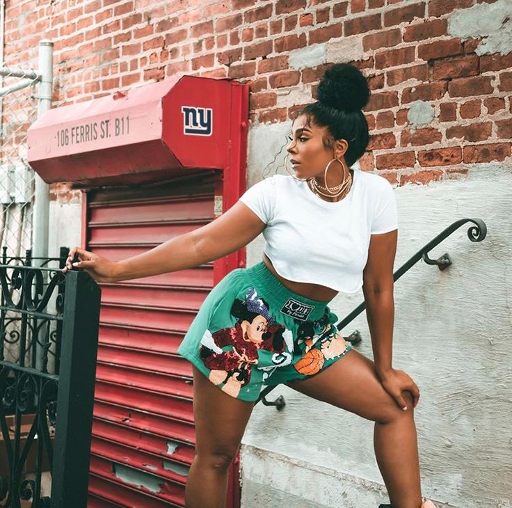 a woman leaning up against a brick wall