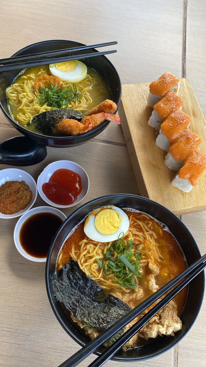 two bowls of ramen with chopsticks and sushi on the side next to each other