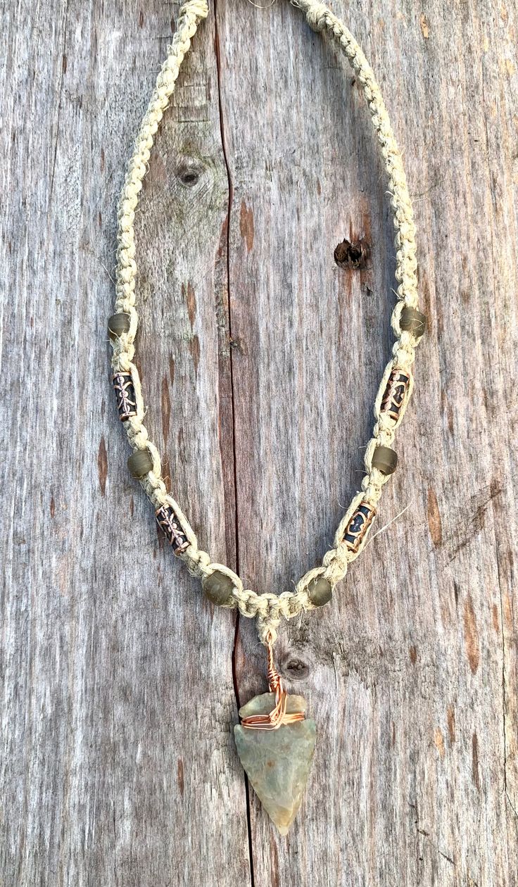 This handcrafted hemp choker features a unique arrowhead pendant made from flint stone, wrapped in copper wire. The pendants vary slightly in size, color, and texture, ensuring every piece is one-of-a-kind. Customizable lengths from 14 to 20 inches make this an adaptable accessory for any style. Ideal for lovers of primitive or tribal-inspired jewelry, this necklace showcases earthy tones and natural craftsmanship, perfect for men or anyone embracing bohemian aesthetics. Proudly made in the USA, Bohemian Necklace With Sliding Knot On Waxed Cord, Hippie Jewelry With Sliding Knot In Waxed Cord, Hippie Jewelry With Sliding Knot On Waxed Cord, Adjustable Waxed Cord Hippie Necklace, Rustic Adjustable Necklace With Waxed Cord, Adjustable Rustic Necklace With Waxed Cord, Adjustable Cord Necklace For Festivals, Adjustable Earthy Necklaces With Waxed Cord, Adjustable Wire Wrapped Arrowhead Necklace