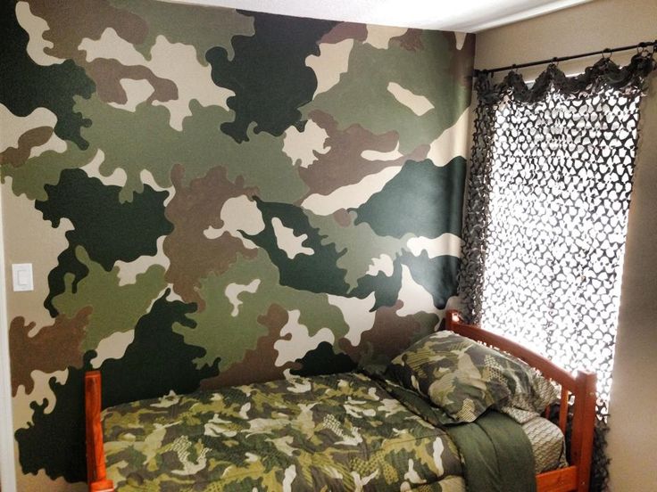 a camo print wallpaper in a bedroom with a twin bed and window curtain